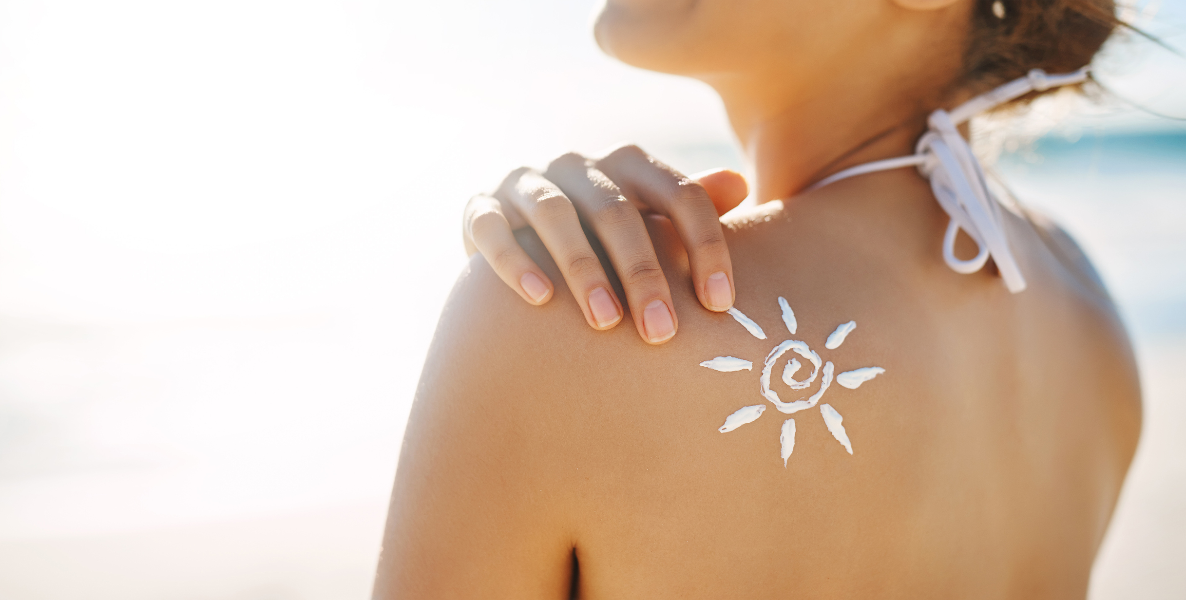 A woman applying mineral sunscreen in the shape of spirally sun