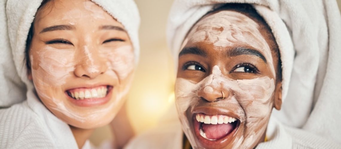 Skincare, face and women friends in a bedroom with mask, application and spa day bonding in their home. Beauty, cream and people with self care sleepover, facial or cosmetic wellness on the weekend